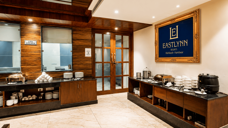 Buffet counter set up near the restaurant entrance with serving dishes at Eastlynn Resort, Rishikesh.
