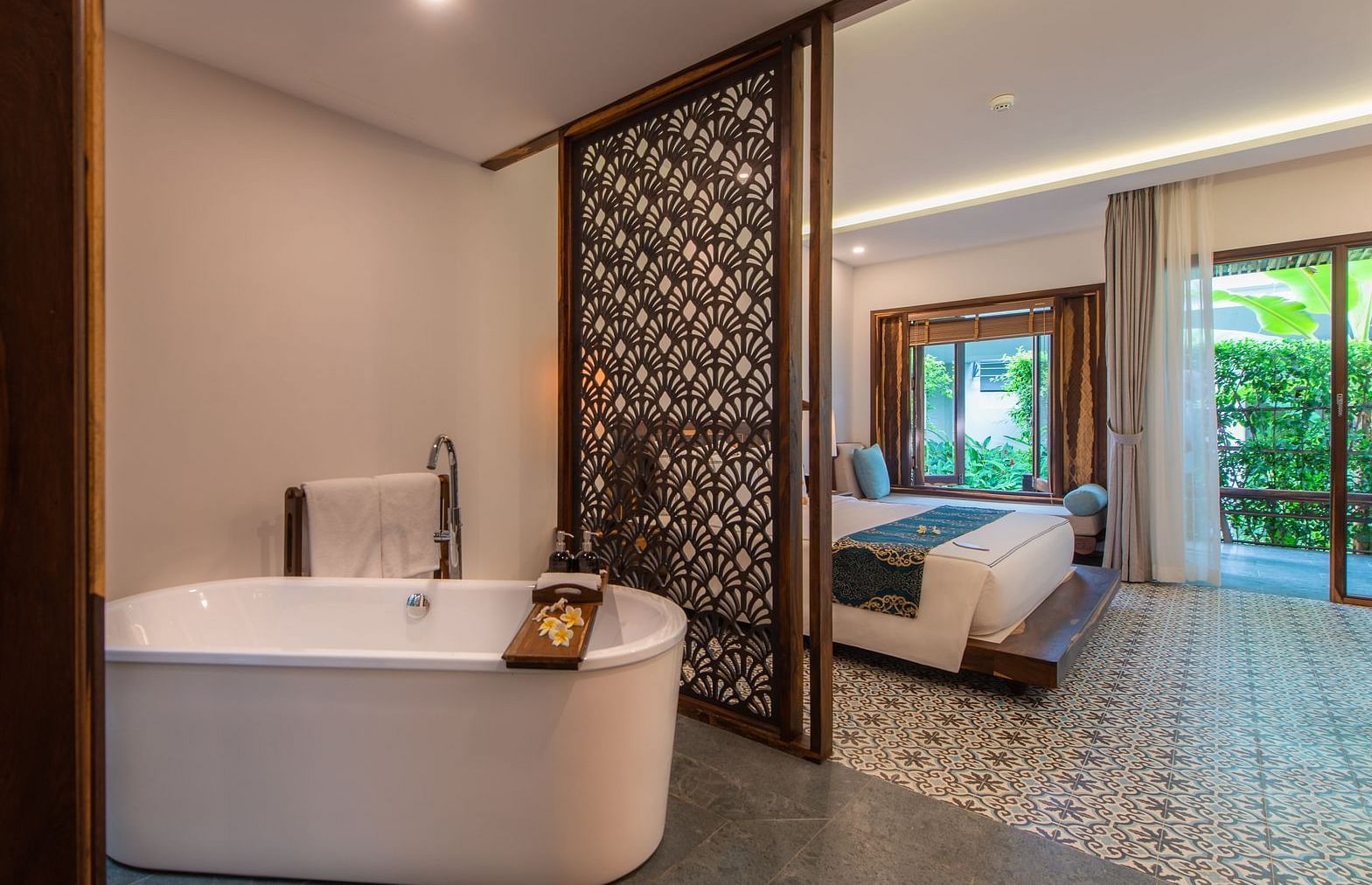 A bathtub in our living room separated by a wooden door from the bedroom - Alibu Resort Nha Trang