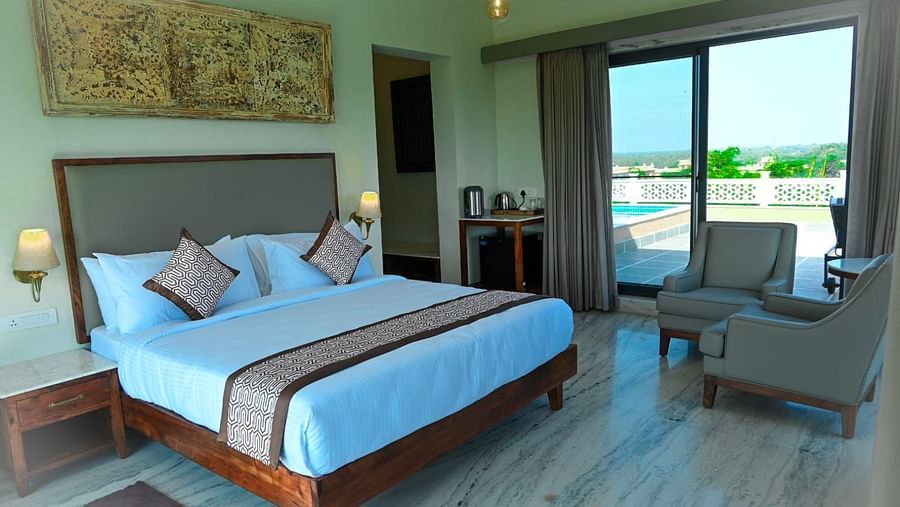 An image of our treatment space with a large bed and a window opening to the beautiful views of our property in Udaipiur - Rajbagh Wellness, Udaipur