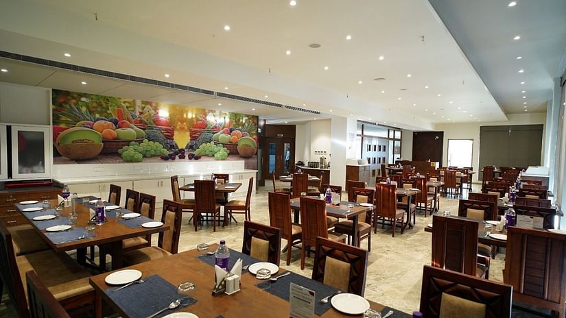 Tables organised with cutlery at Kamats Original family Restaurant under ambient lights