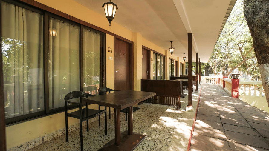 An inviting outdoor lobby at Adamo The Village featuring comfortable seating, large windows, and elegantly draped curtains.