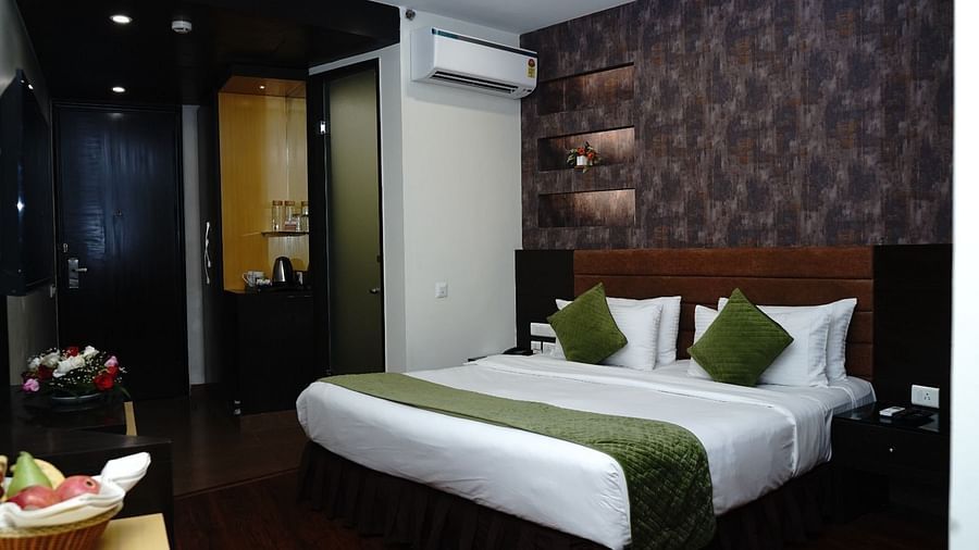 An image of Deluxe Room featuring a double size bed, bedside table on either side,  flat TV screen, AC, fruit basket and bouquets, and tea and coffee maker at Five Elements Hotels North Avenue, Delhi
