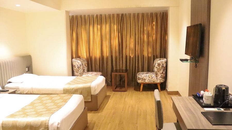 Deluxe Room with twin beds having cream bed covers at Hotel Diplomat