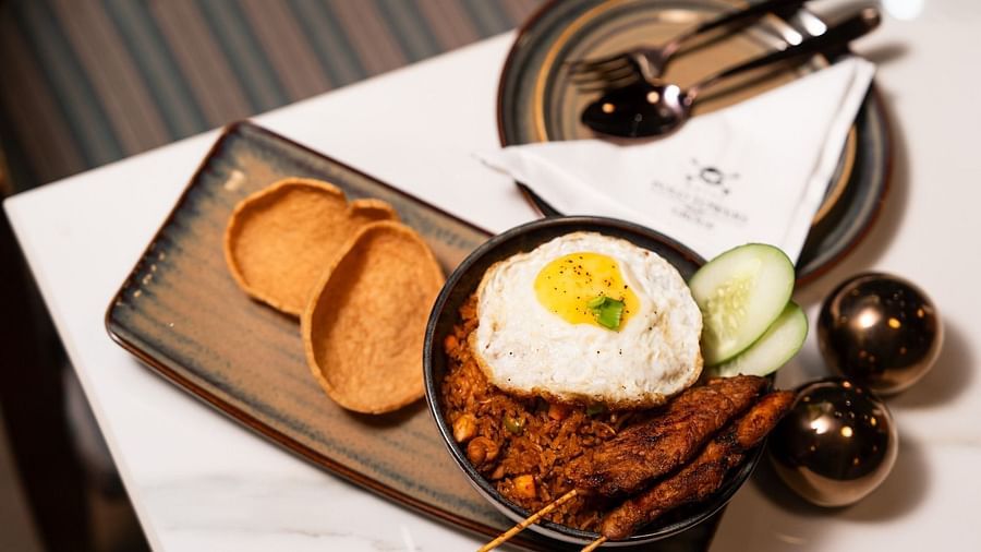 An image featuring a rectangular plate with chips, a rice bowl, and an additional plate on the side with cutlery and a tissue.