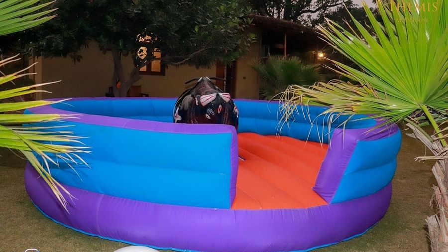 Mechanical bull ride surrounded by trees at inflated trampoline surrounded by trees at Themis Mudhouse - A Nature's Retreat Resort & Wellness