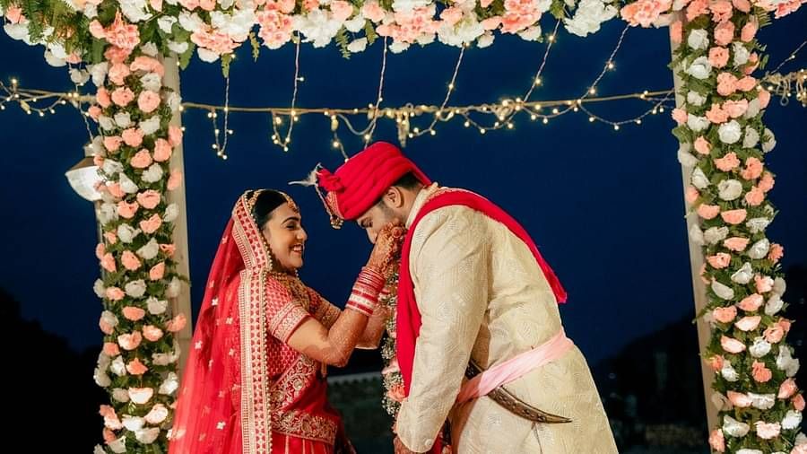 A bride placing the garland around the groom's neck