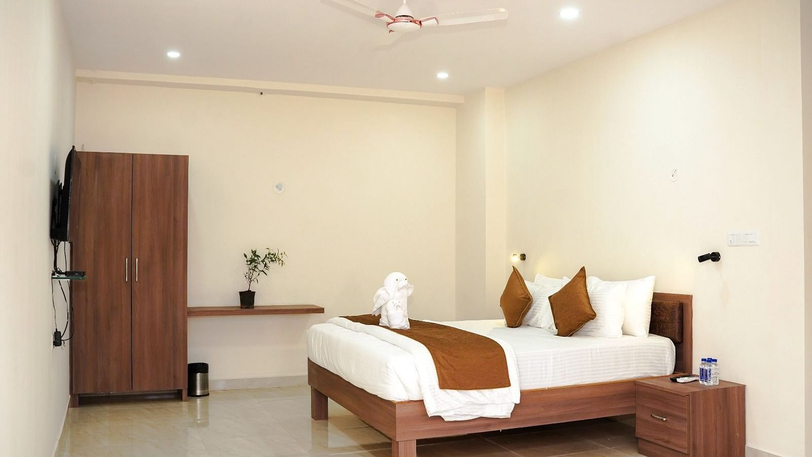 Well-lit room with a double bed and a wardrobe at ANS M Square Hotel & Resort, Kalaburagi