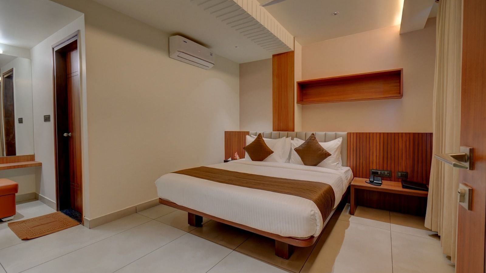 An image of a room at Hari Govindas, Siddappa Square, featuring a bed with a door on the side.