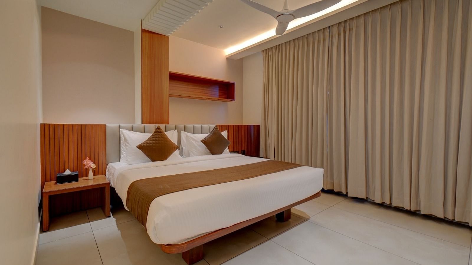 Image of a room with a bed and a table beside it at Hari Govindas, Siddappa Square.