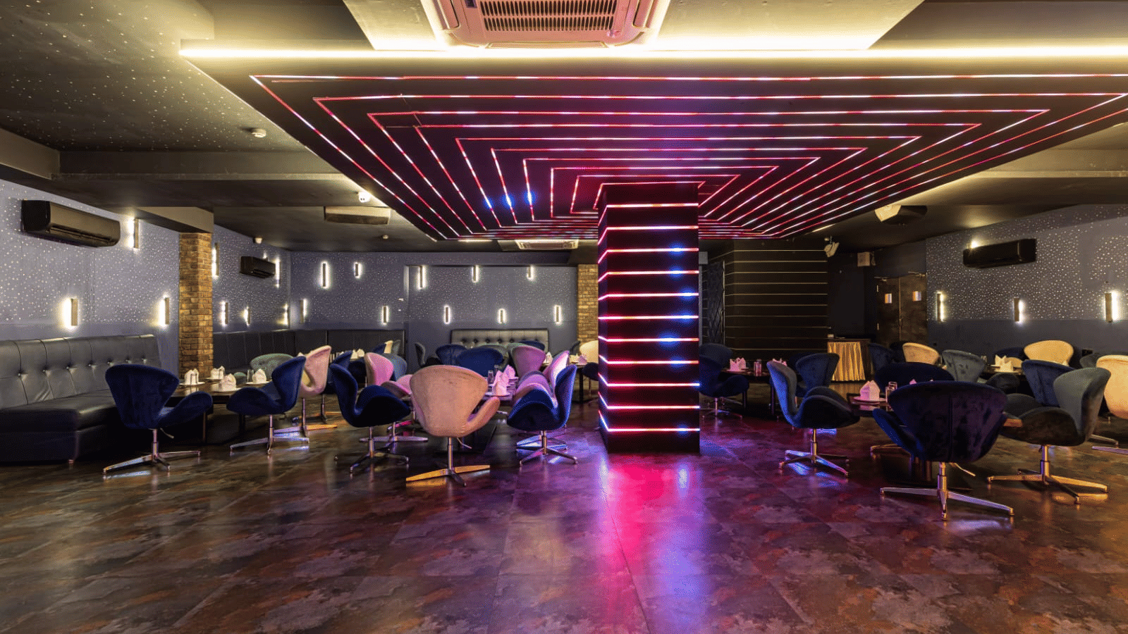 Stylish indoor lounge of Papaya Tree Hotels with patterned ceiling lighting and modern seating arranged across a spacious floor area at Re-Pub-Liq.