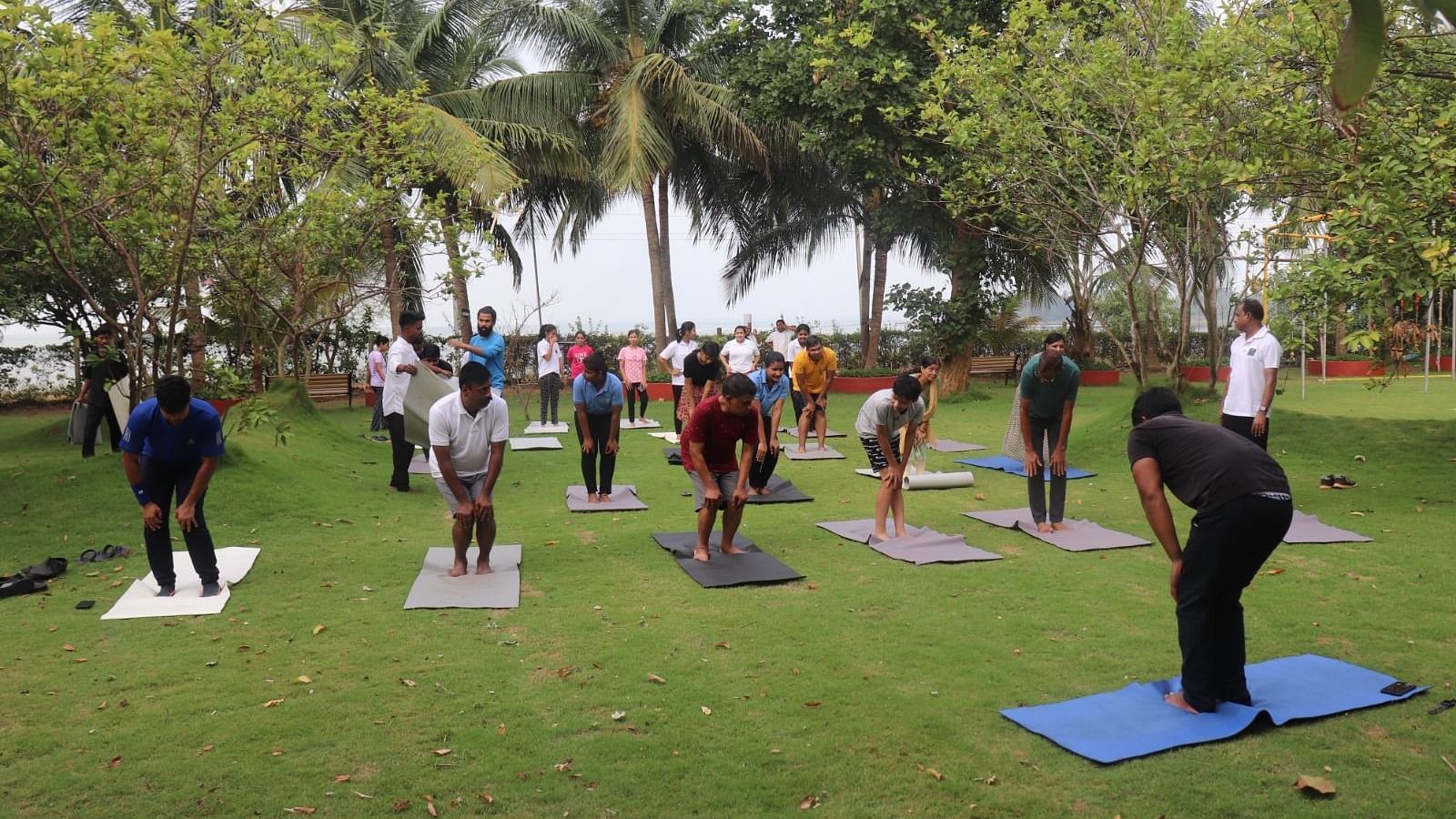 People practising yoga in the garden area at Swosti Resorts on a sunny day