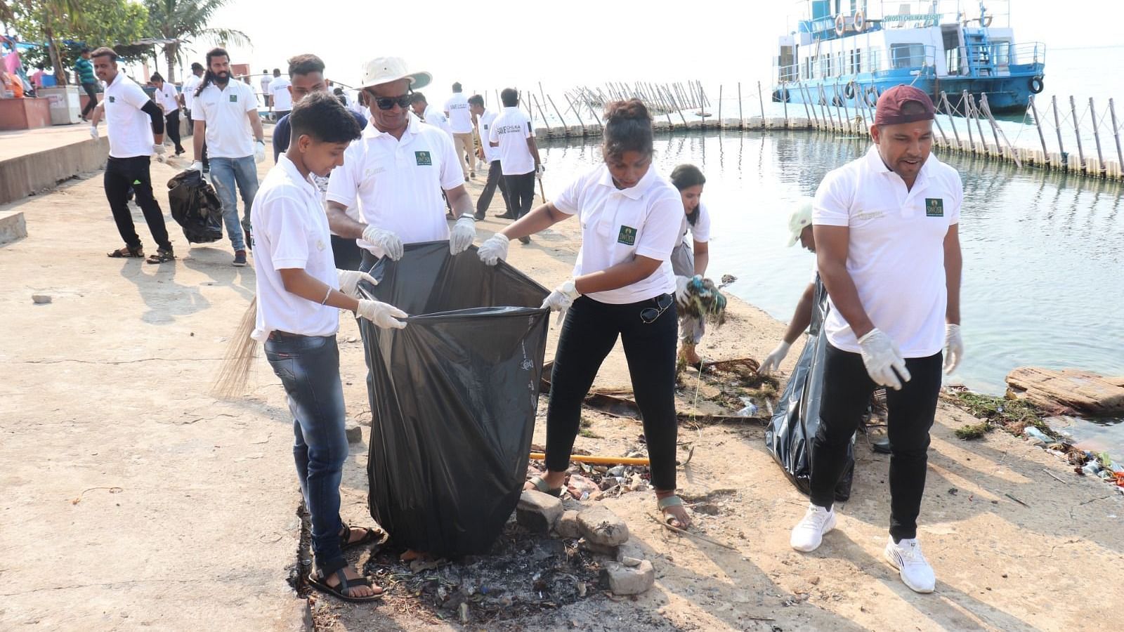 People cleaning up a river bank during the day