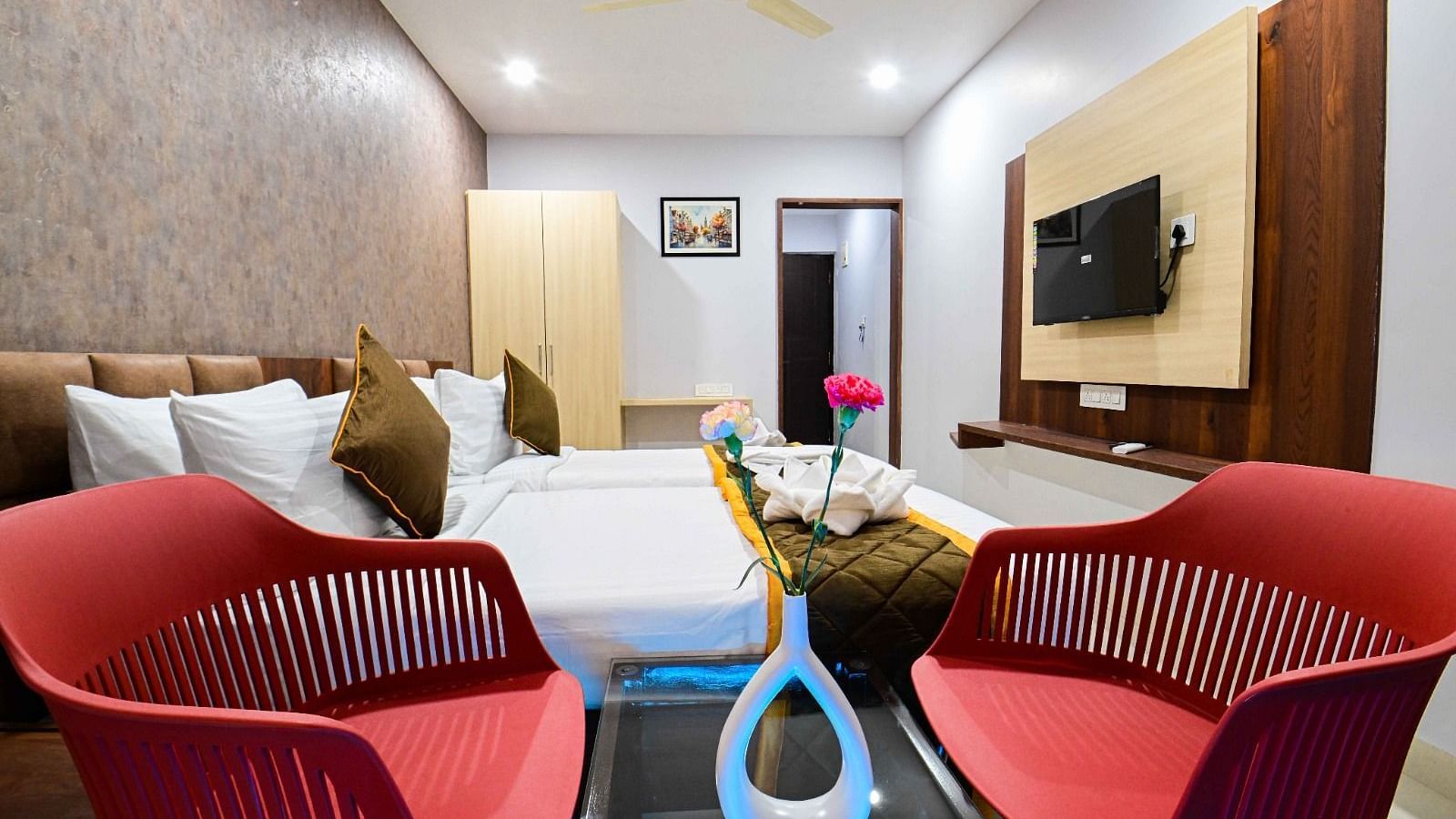 view of the  comfortable sofa setting and TV  and king size bed of Premium Balcony Room at at South Square Hotel, Bengaluru