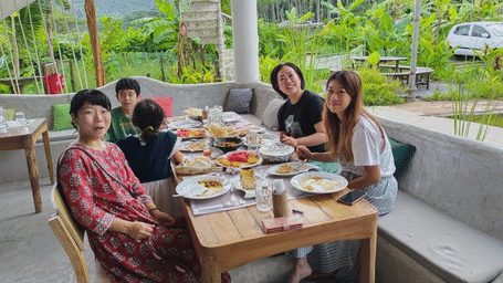 Family enjoying a relaxed outdoor meal at Matsya Island Retreat, surrounded by lush greenery and a peaceful tropical setting in Havelock Island.