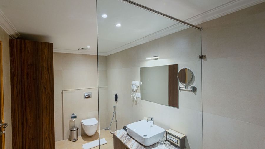 Modern bathroom at Bamboo Saa Resort & Spa, Udaipur with glass shower and vessel sink.