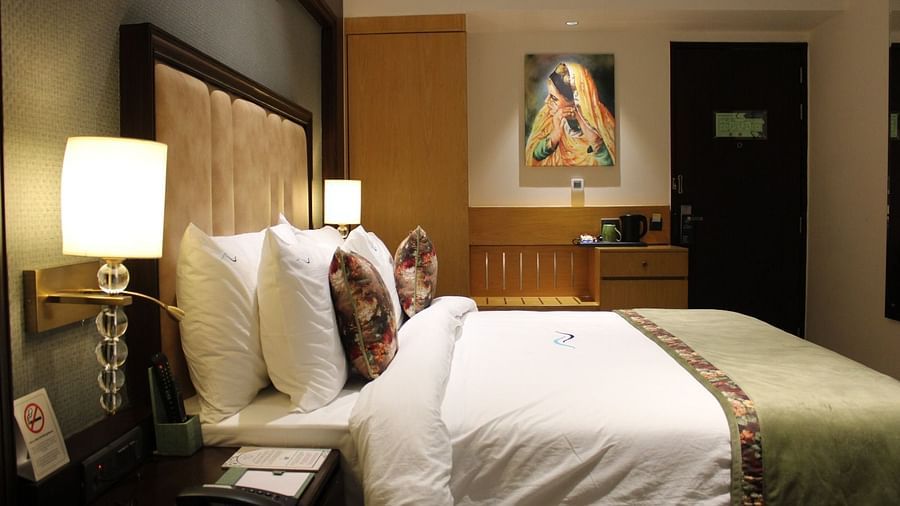 A side view of the bedroom with a tea and coffee makeer placed on the table at BluSalzz Residence, Amritsar