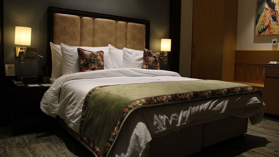 A room with a king size bed, patterned headboard, and lamps at BluSalzz Residence, Amritsar
