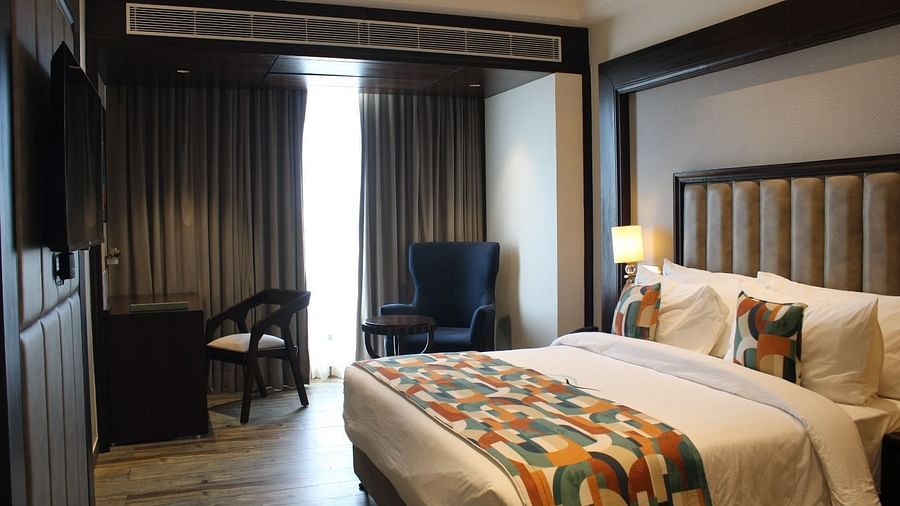 A bedroom with a window draped in curtains at BluSalzz Residence, Amritsar