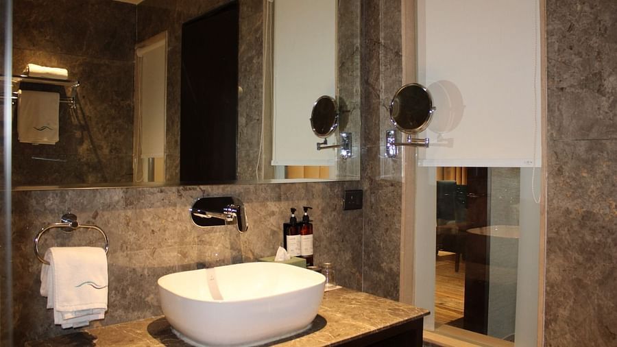 A bathroom with a wash basin and a mirror 