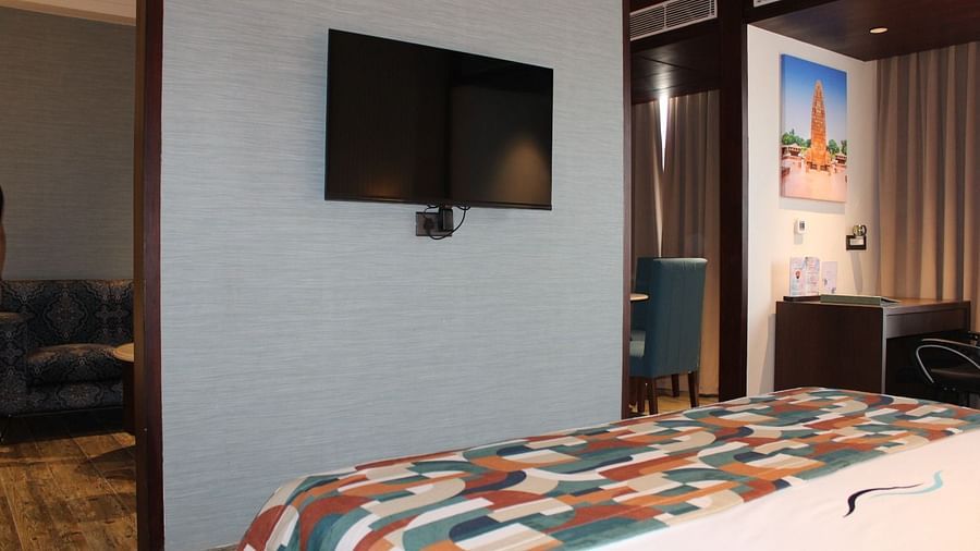 A wall mounted television  in a bedroom facing the bed at BluSalzz Residence, Amritsar