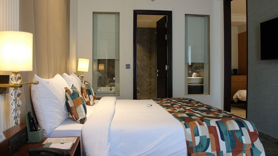 A side view of a bedroom with the bathroom door open, showcasing the interior at BluSalzz Residence, Amritsar