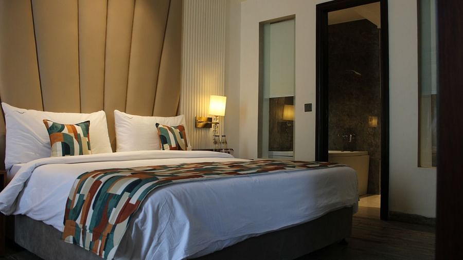 A bedroom with a patterned headboard and a lamp illuminating yellow light next to the bed at BluSalzz Residence, Amritsar.