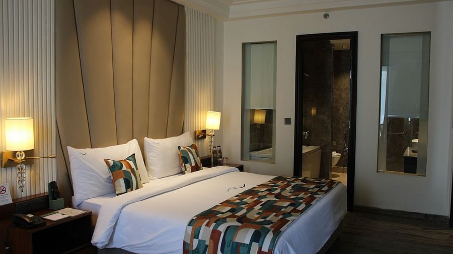 Side view of a bedroom featuring two lamps next to each other on either side of the bed at BluSalzz Residence, Amritsar