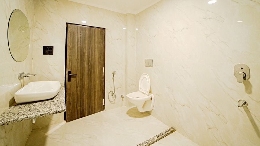 Modern bathroom at Grassfield Riveria Resort, Jaipur, featuring a wall-mounted sink, toilet, and clean, minimalist design.