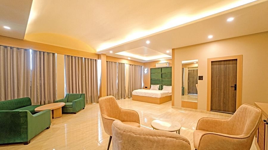 Spacious, well-lit room at Grassfield Riveria Resort, Jaipur, featuring comfortable seating, large bed, and modern amenities.