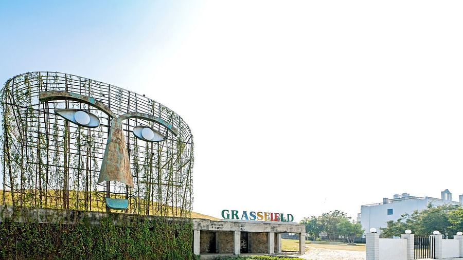 Entrance of Grassfield Riveria Resort, Jaipur, featuring a large artistic mask sculpture and the resort’s name displayed prominently.