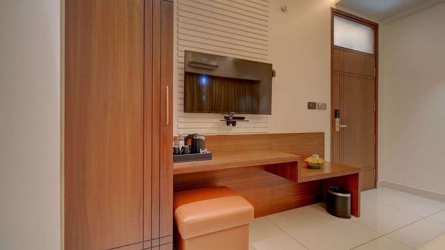 An image of a room featuring a wooden table with a tray placed on top at Hari Govindas, Siddappa Square.