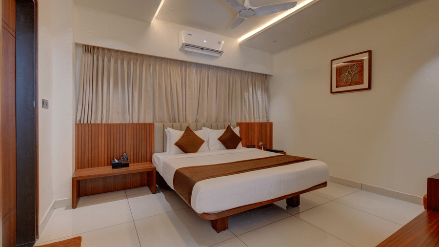 The superior room at Hari Govindas, Siddappa Square, featuring a bed with an air conditioner mounted above it.