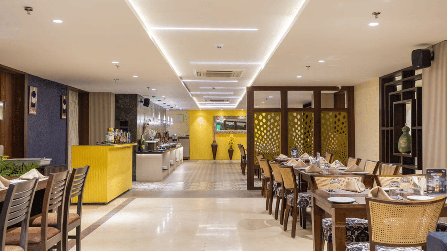 Bright and contemporary restaurant at Papaya Tree Hotels featuring an open layout, modern lighting, and well-arranged dining tables.