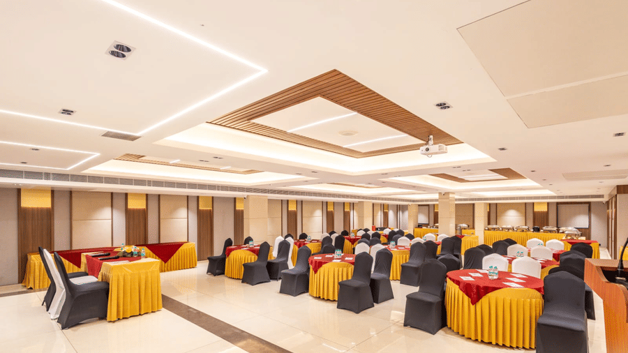 Banquet hall at S Convention Centre configured with round tables and linens in a cluster arrangement, ideal for workshops or social gatherings at S Hotels, Chennai.