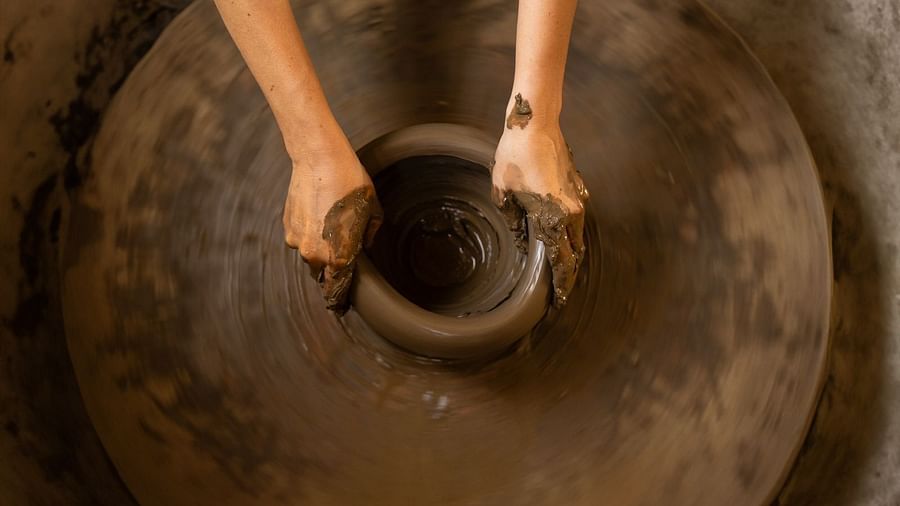 Top view of a hand moulding clay on a wheel at Surpura Bagh.