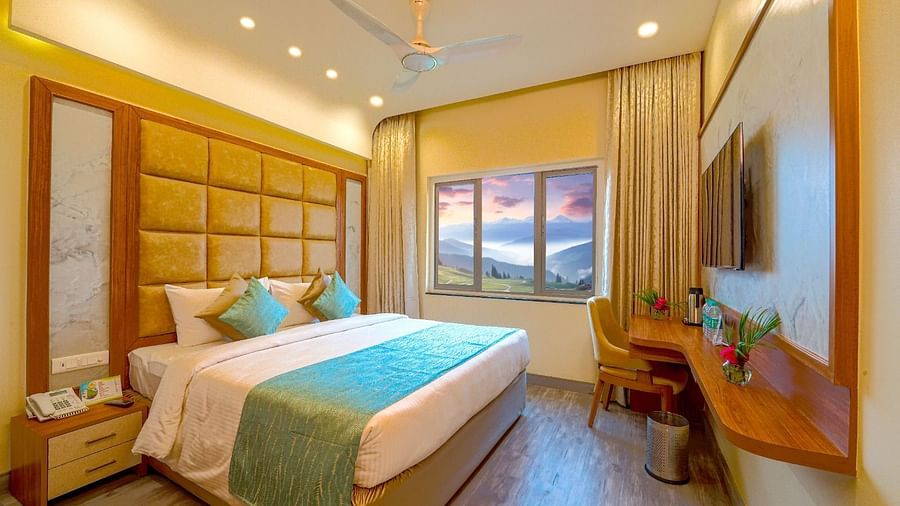 Cozy bedroom with a queen-sized bed, elegant headboard, and large window offering natural light Tara, Comfort Hotel in Hyderabad - Ramoji Film City.