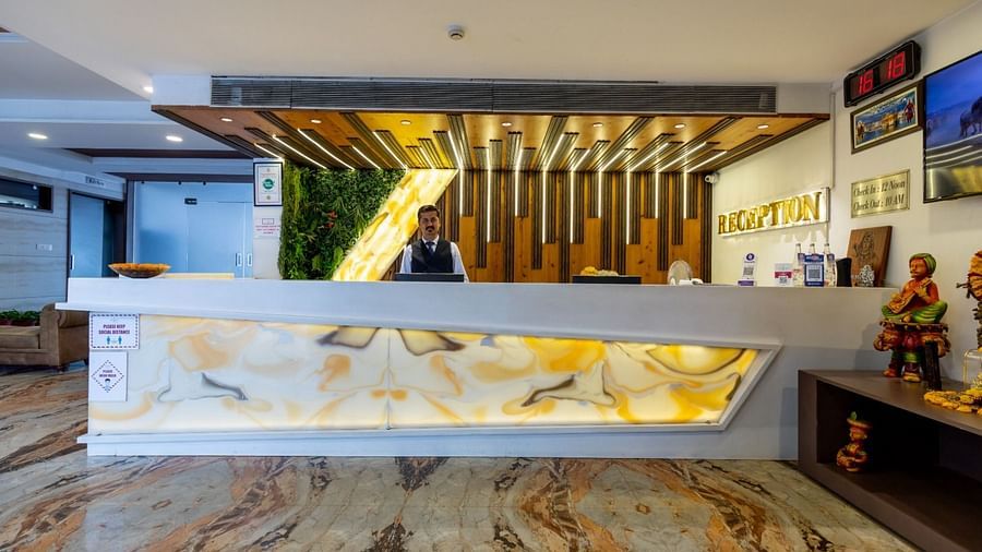 A modern hotel reception desk with warm lighting and cultural decor - TGI Insignia, Bhopal
