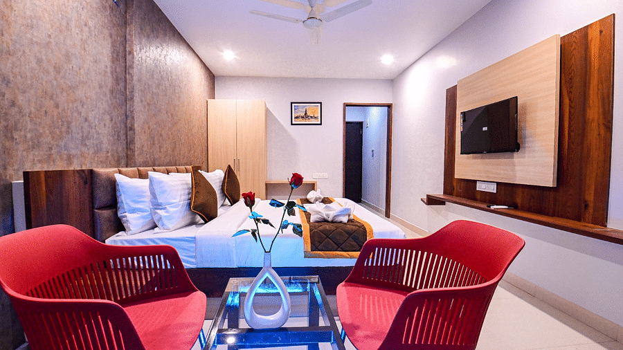 view of the  comfortable sofa setting and TV with twin beds of Twin Deluxe Room of the South Square Hotel, Bengaluru