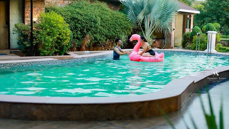 Two people in a swimming pool with one sitting on a pink floatie at Valley by Grassfield.