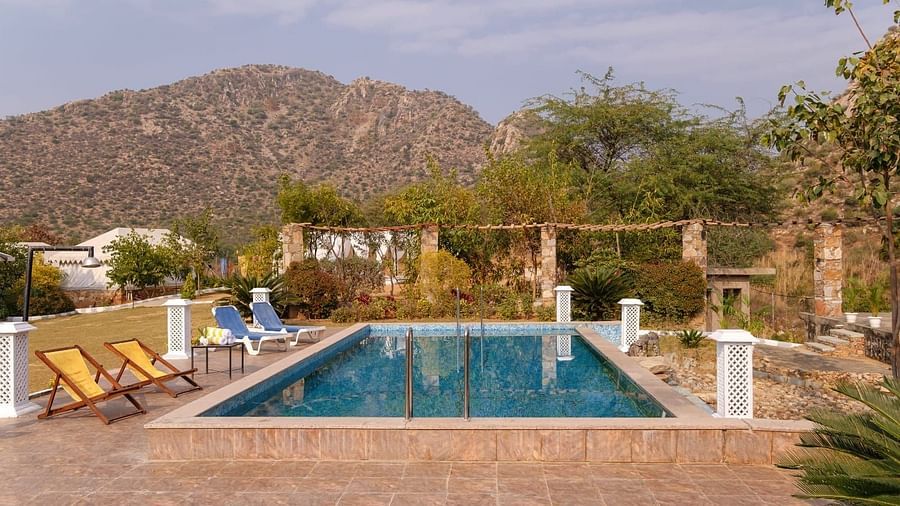 A swimming pool with lounge chairs by the side surrounded by plants at Valley by Grassfield.