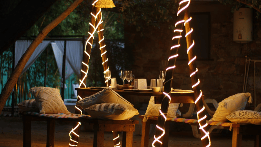 Patio seating with cushions and string lights at Valley by Grassfield, a resort in Jaipur.