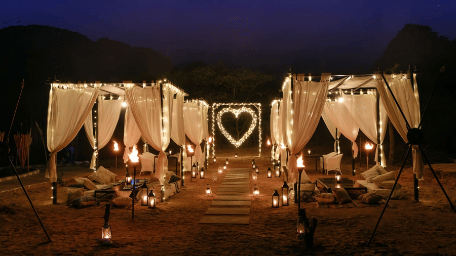 Outdoor event cabana dressed with white curtains and lights at Valley by Grassfield, a wedding venue in Jaipur.