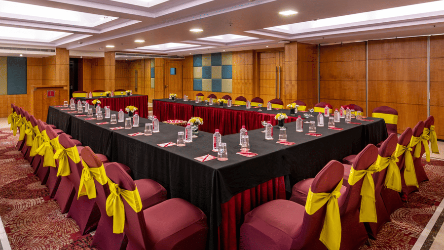 a large boardroom with U-shaped seating arrangements  with wood-panelled walls and ceiling lights at Libra Lords Inn Jaipur