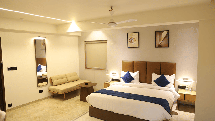 A well appointed bedroom at Lords Studio Inn, Jamnagar featuring a large bed and elegant decor.