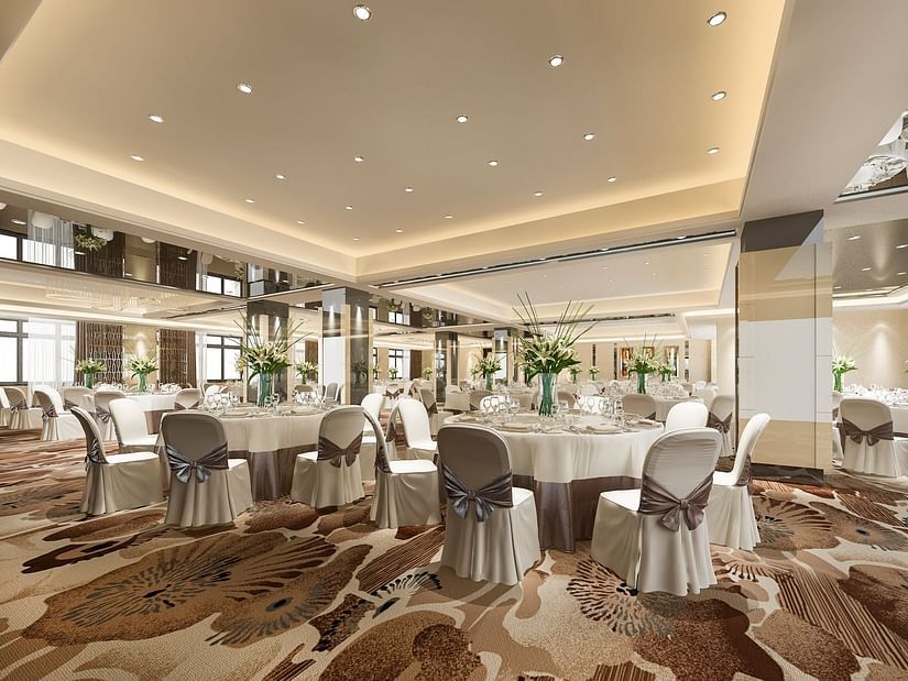A banquet hall with round table arrangement of chairs and tables, facing the dais