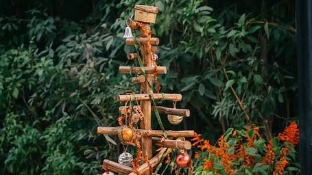 Wooden decorative tree structure placed in a garden area at Karma Chalets.
