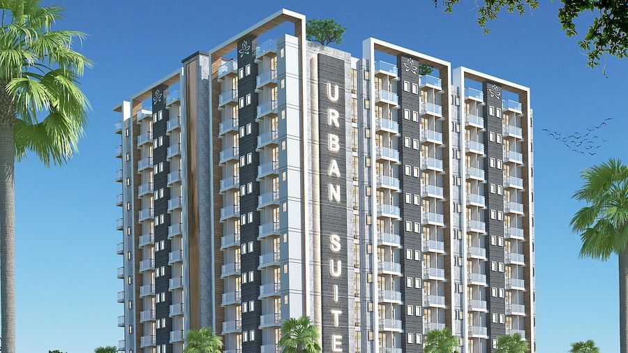 Facade view of Urban Suites by BluSalzz, Jaipur against the sky, with tree leaves framing the foreground.