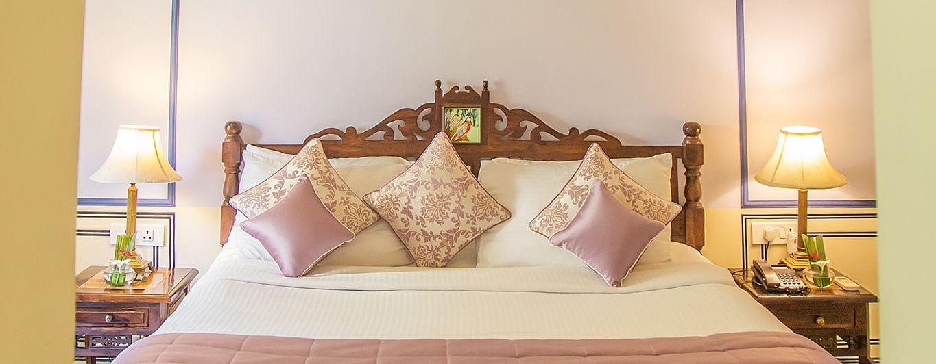 A bedroom at Royal Heritage Haveli with a large bed under a decorative canopy and an arched entrance.
