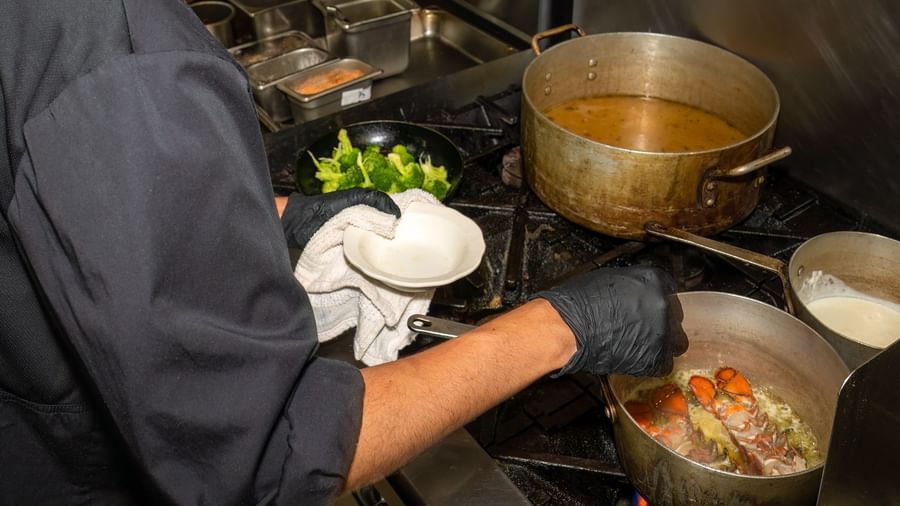 Chef cooking fresh seafood at the stove in the kitchen of Narrow Gauge Inn.