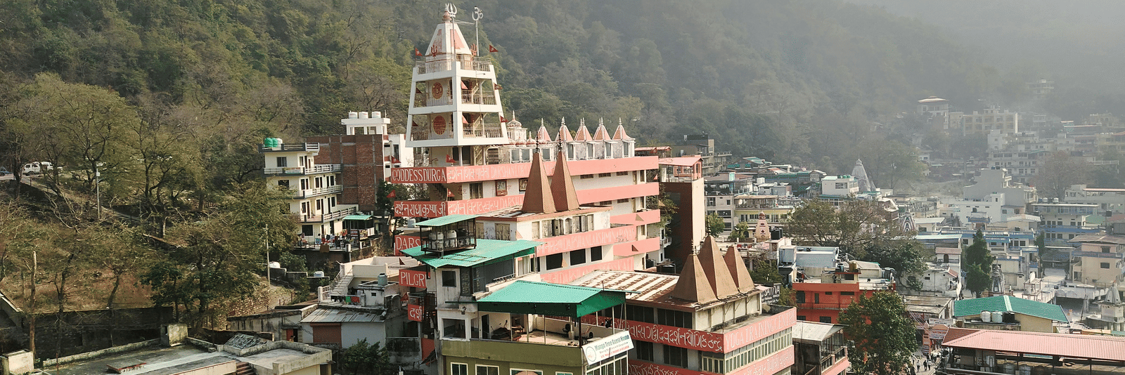 A group of buildings situated in front of a majestic mountain backdrop.
